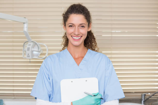 istock Dentist in blue scrubs holding clipboard 816446674