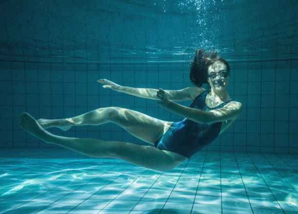 istock Athletic swimmer smiling at camera underwater 816458246