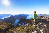 Hiker on top of mountain with view of norwegian fjord