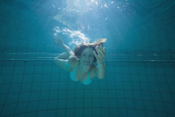 At the pool, Asian women are diving. She had on a bikini.