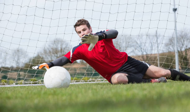 istock Goalkeeper in red saving a goal during a game 816477294