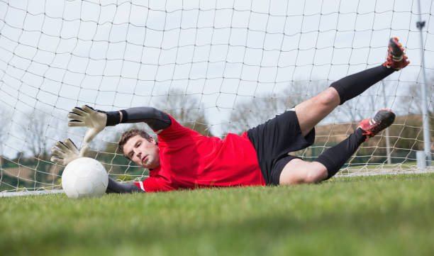 istock Goalkeeper in red saving a goal during a game 816477358