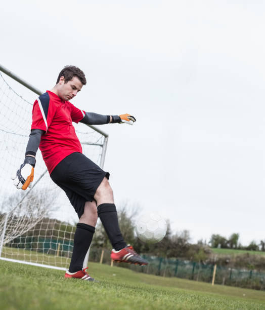 istock Goalkeeper in red kicking ball away from goal 816477410
