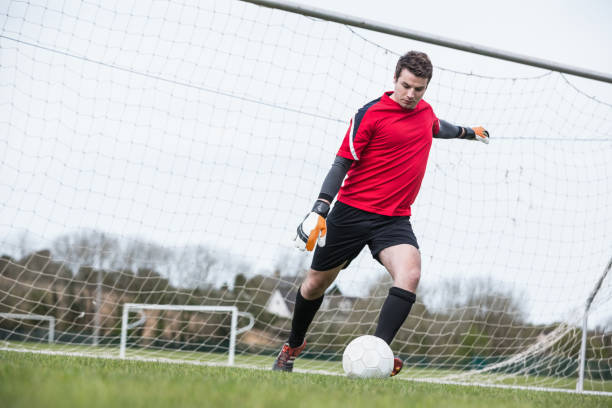istock Goalkeeper in red kicking ball away from goal 816477454