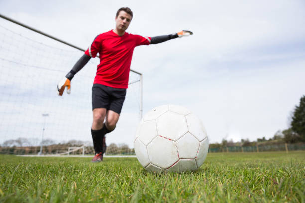 istock Goalkeeper in red kicking ball away from goal 816477648