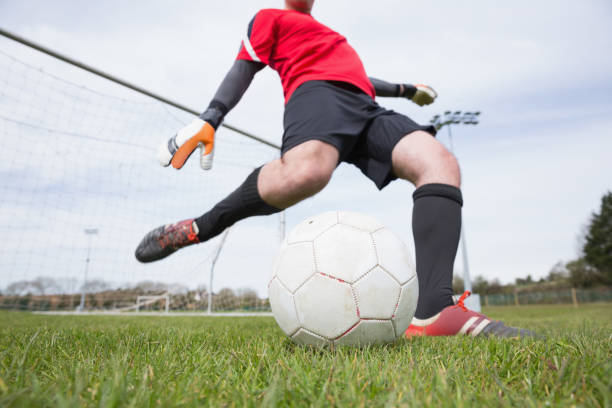 istock Goalkeeper in red kicking ball away from goal 816477670