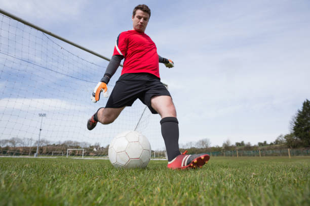 istock Goalkeeper in red kicking ball away from goal 816479700