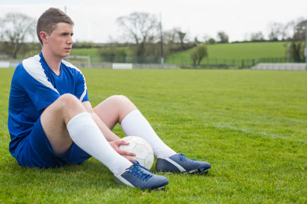 istock Football player in blue taking a break on the pitch 816497524