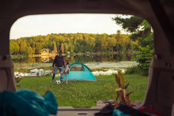 madre e hija jugando al fútbol por el lago - canadian football fotografías e imágenes de stock