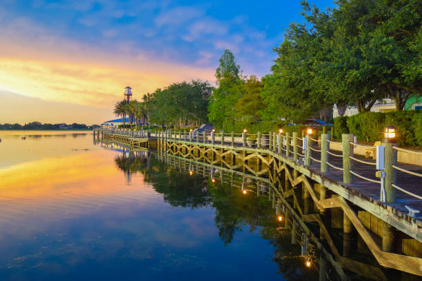 Waterfront Boardwalk at Sunset in The Villages, Florida Sunset on the boardwalk on the waterfront at The Villages, Florida. orlando florida stock pictures, royalty-free photos & images