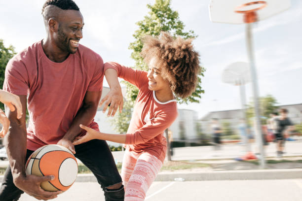 tata gra w koszykówkę z córką - basketball playing ball african descent zdjęcia i obrazy z banku zdjęć