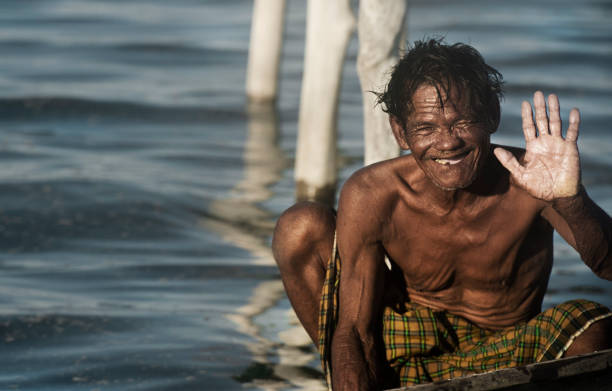 Bajau Sea Gypsies of Borneo on a Boat, Sabah Semporna, Sabah, Malaysia - April 22, 2016: Unidentified Sea Gypsies kids on a boat at Sea Gypsy village in Maiga Island, Semporna, Sabah, Malaysia. They inhabit villages built on stilts in the middle of ocean. Boat is the main transportation in the area. mabul island stock pictures, royalty-free photos & images