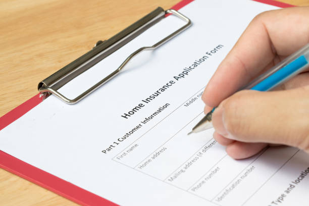 istock Mand fill the home insurance application form with red file on wooden table 816583204