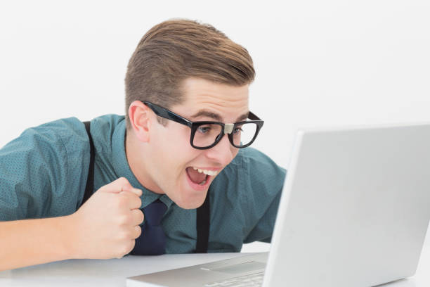 istock Nerdy businessman at his desk looking at laptop 816585554