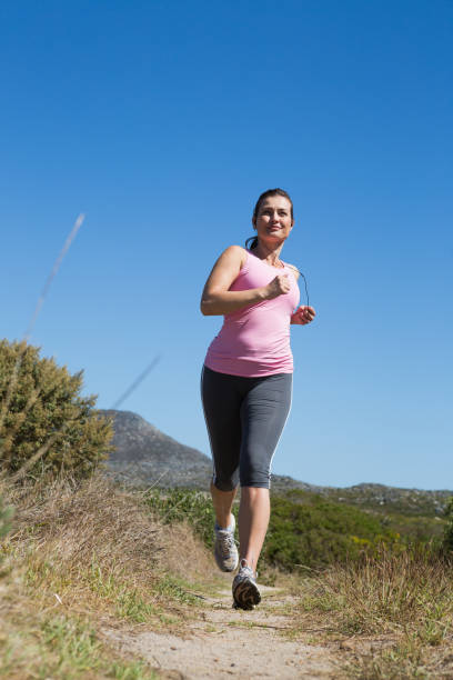 aktive frau joggen in der natur - running jogging footpath cross country running stock-fotos und bilder