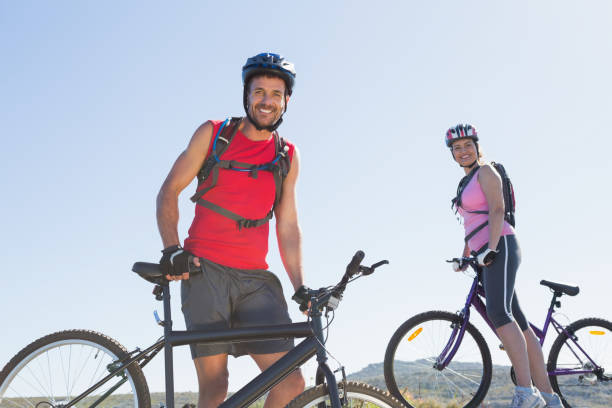 istock Fit cyclist couple standing at the summit smiling at camera 816610314