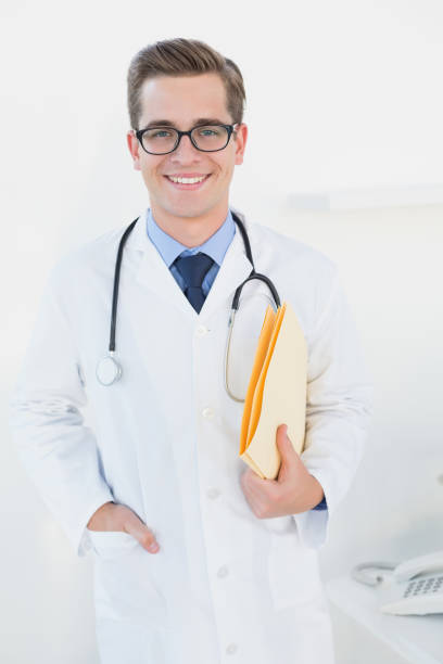 istock Smiling young doctor holding folder looking at camera 816610378
