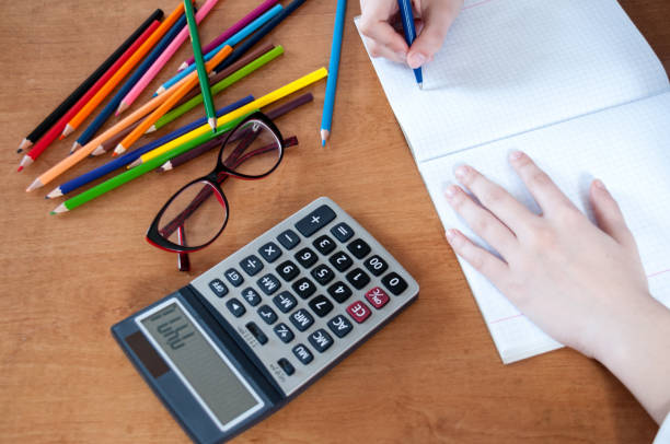 istock Student writes in notebook, on  table colored pencils and calculator 816630966