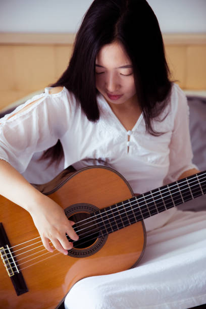 istock Young woman playing guitar 816689800