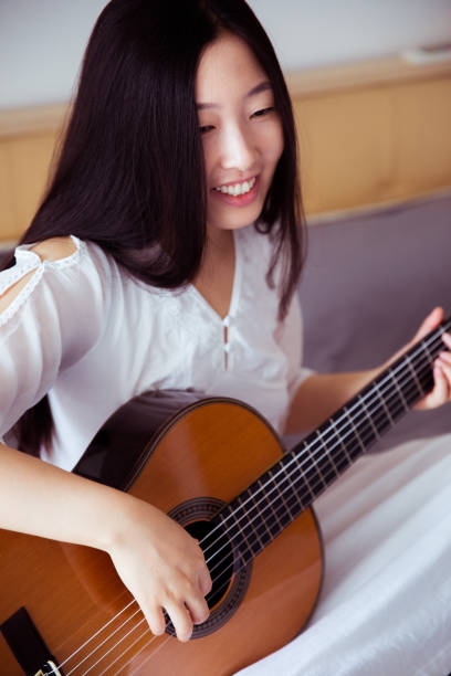 istock Young woman playing guitar 816689856