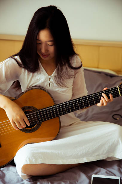 istock Young woman playing guitar 816689964