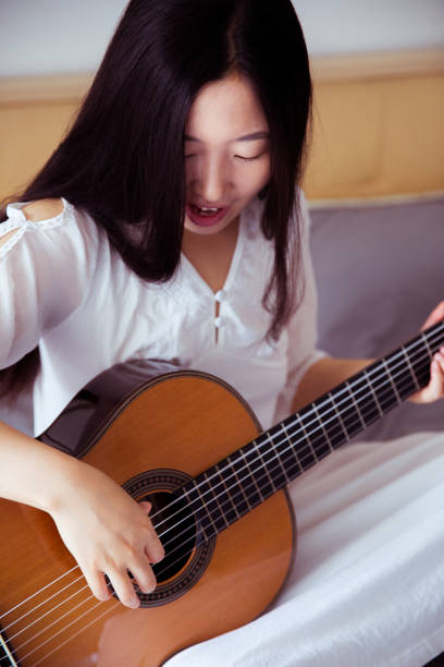 istock Young woman playing guitar 816692712