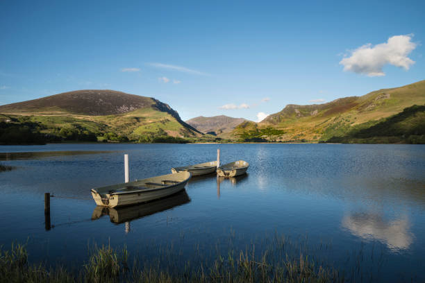 istock Stunning dramatic stormy sky formations over breathtaking mountain lake landscape with rowing boats in foreground 816720722