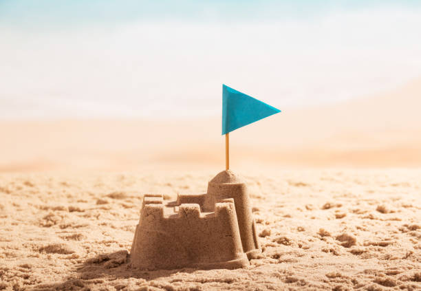 istock Tower from sand and blue flag on coast. 816743560
