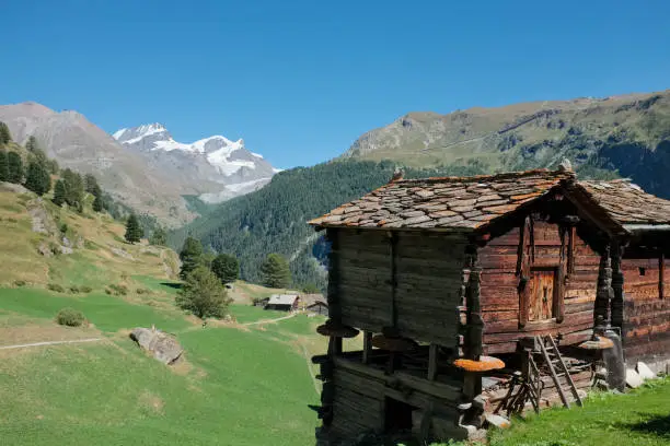 Image shows typical old Swiss wooden huts with view on Monterosa massif in the background, Wednesday 24 August 2016, near Zermatt, Switzerland.