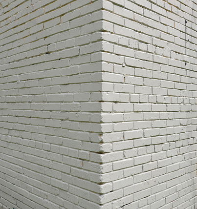 House corner, brick wall painted with white paint.