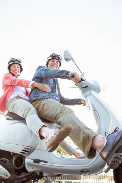 istock Happy senior couple riding a moped 816774436