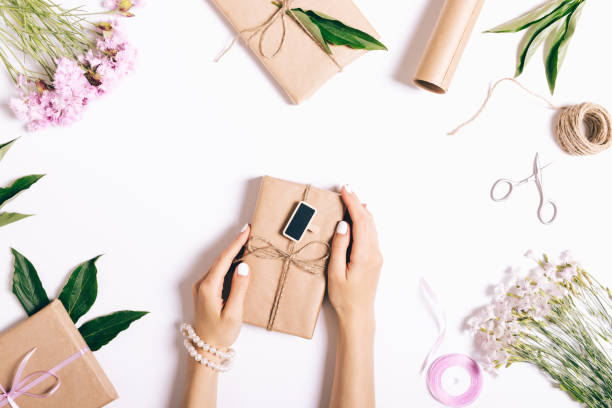 istock Female hands holding gifts on the table with decorations 816780348