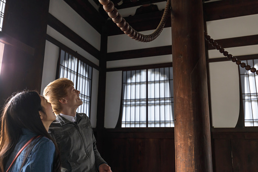 A young multinational couple wearing casual wear is enjoying dates at Japanese temples.