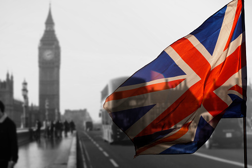 British union jack flag and Big Ben Clock Tower and Parliament house at city of Westminster in the background - UK votes to leave the EU, Brexit concept