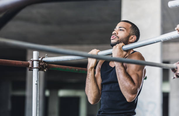 Male Athlete Doing Chin-ups in a Gym Athlete Exercising in a Gym chin ups photos stock pictures, royalty-free photos & images