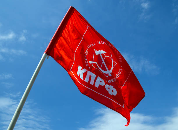 флаг коммунистической партии россии на голубом небе - прежний советский союз стоковые фото и изображения