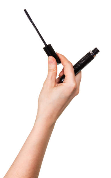 istock Black mascara and tassel in female hand isolated on white. 816802572