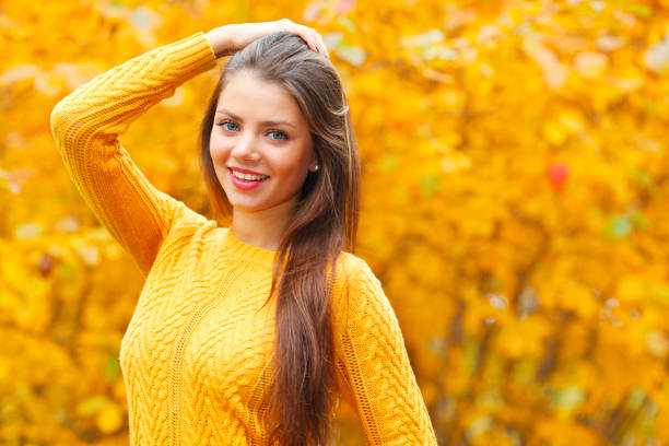 istock Young brunette in autumn park 816820212