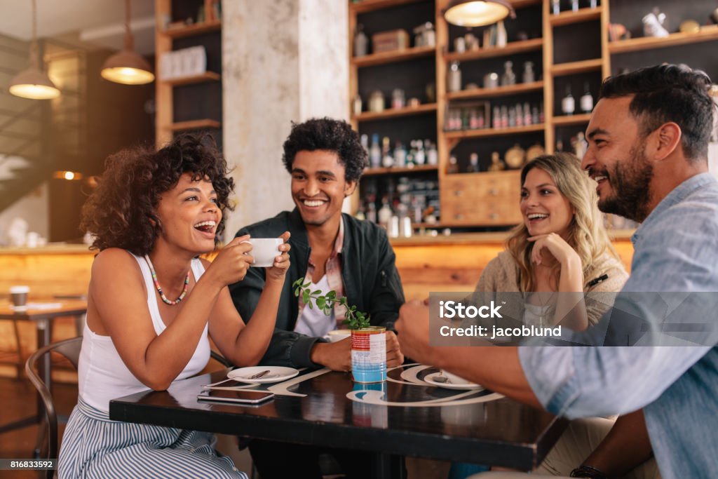 Jóvenes amigos, tener un buen rato en la cafetería - Foto de stock de Amistad libre de derechos