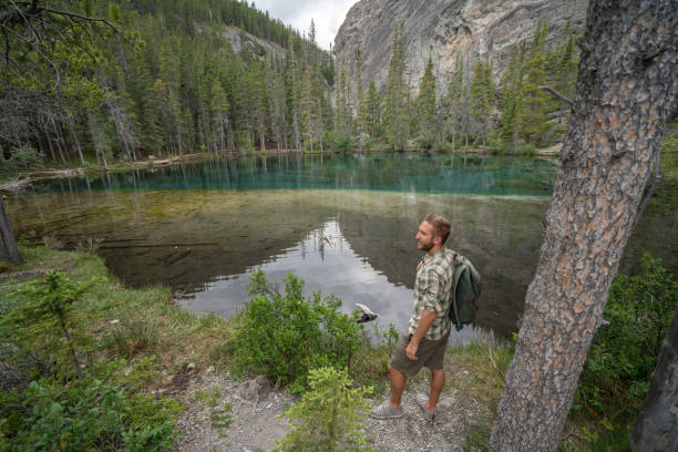 istock Young man hiker stops by mountain lake 816837890