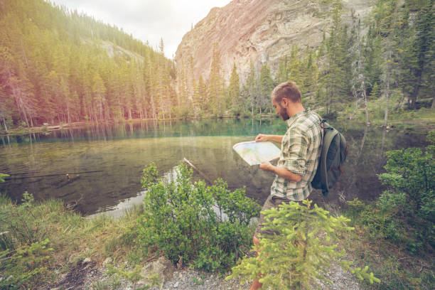 istock Hiker male looking at map near mountain lake 816837892