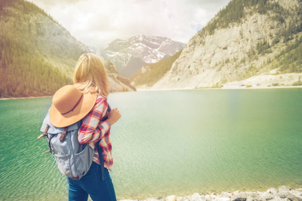 istock Young woman hiker looking at mountain lake 816841092