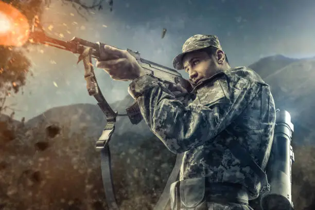 man in military gear shooting action with mountains on background