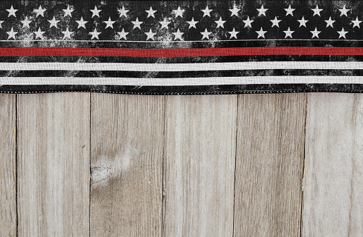 Retro USA patriotic old thin red line flag on a weathered wood background with copy space