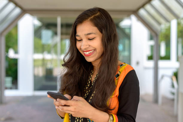 istock Indian woman smiling as she reads a text message 816850094