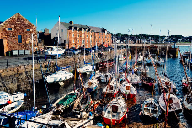 Boats anchored at low tide, by the harbourside of the village of North Berwick on the East Lothian Region of Scotland, on a sunny summer's evening. Situated only 25 miles from Edinburgh, North Berwick is a popular tourist attraction for day trippers, being within easy reach of several famous links golf courses, and possessing a stunning view of the surrounding countryside from the nearby North Berwick Law.