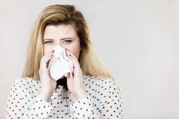 istock Woman being sick having flu sneeze into tissue 816871990