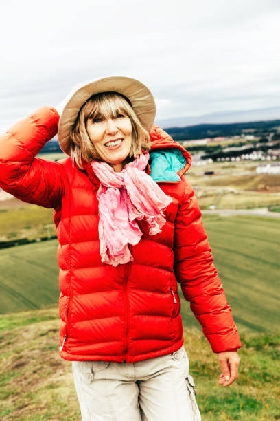istock Senior woman walking on windy day 816877654