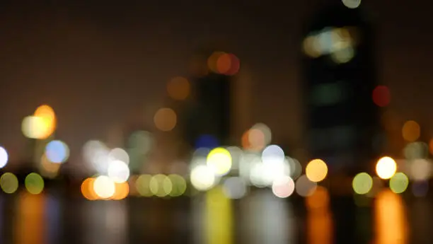 It 's blurred of your eye or your mind ( Bokeh colorful polga dot nightlight with water reflection in downtown of Bangkok, the capital in Thailand )