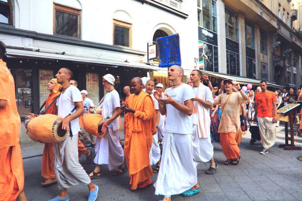 Hare Krishna Movement members dancing and singing on Budapest street, crowds of tourists around, Hungary.